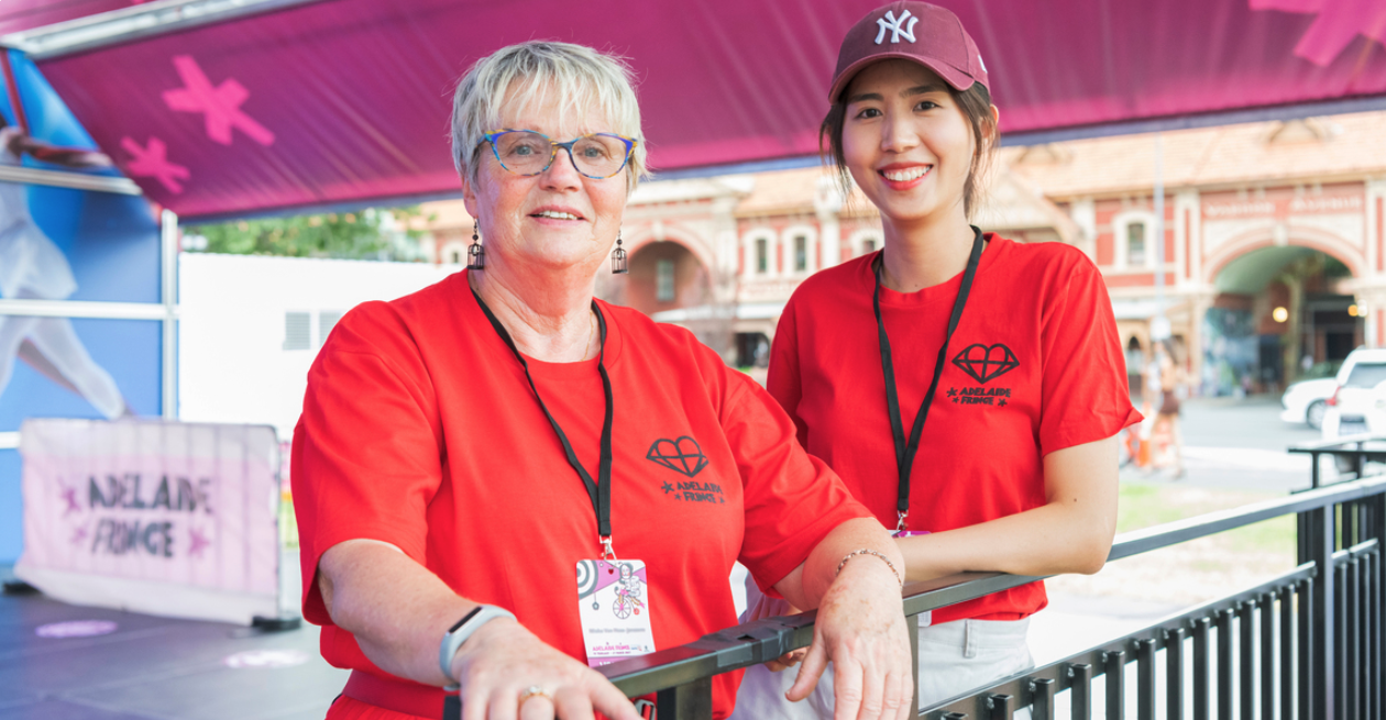 two volunteers smiling with two red shirts