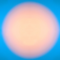 a large peach circle light in the centre, illuminated over a bright blue background