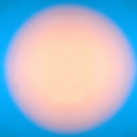 a large peach circular light illuminated over a bright blue background