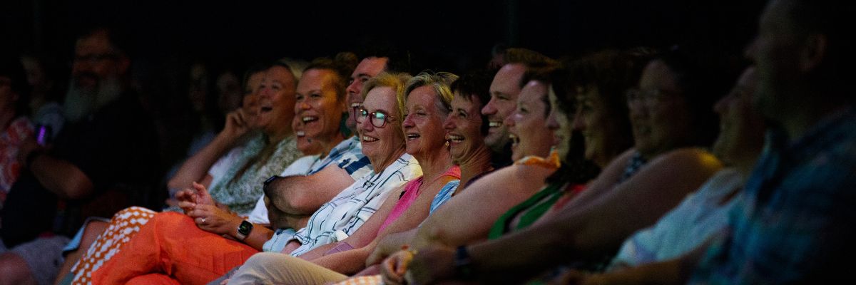 Row of audience members laughing at a show