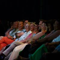 Row of audience members laughing at a show