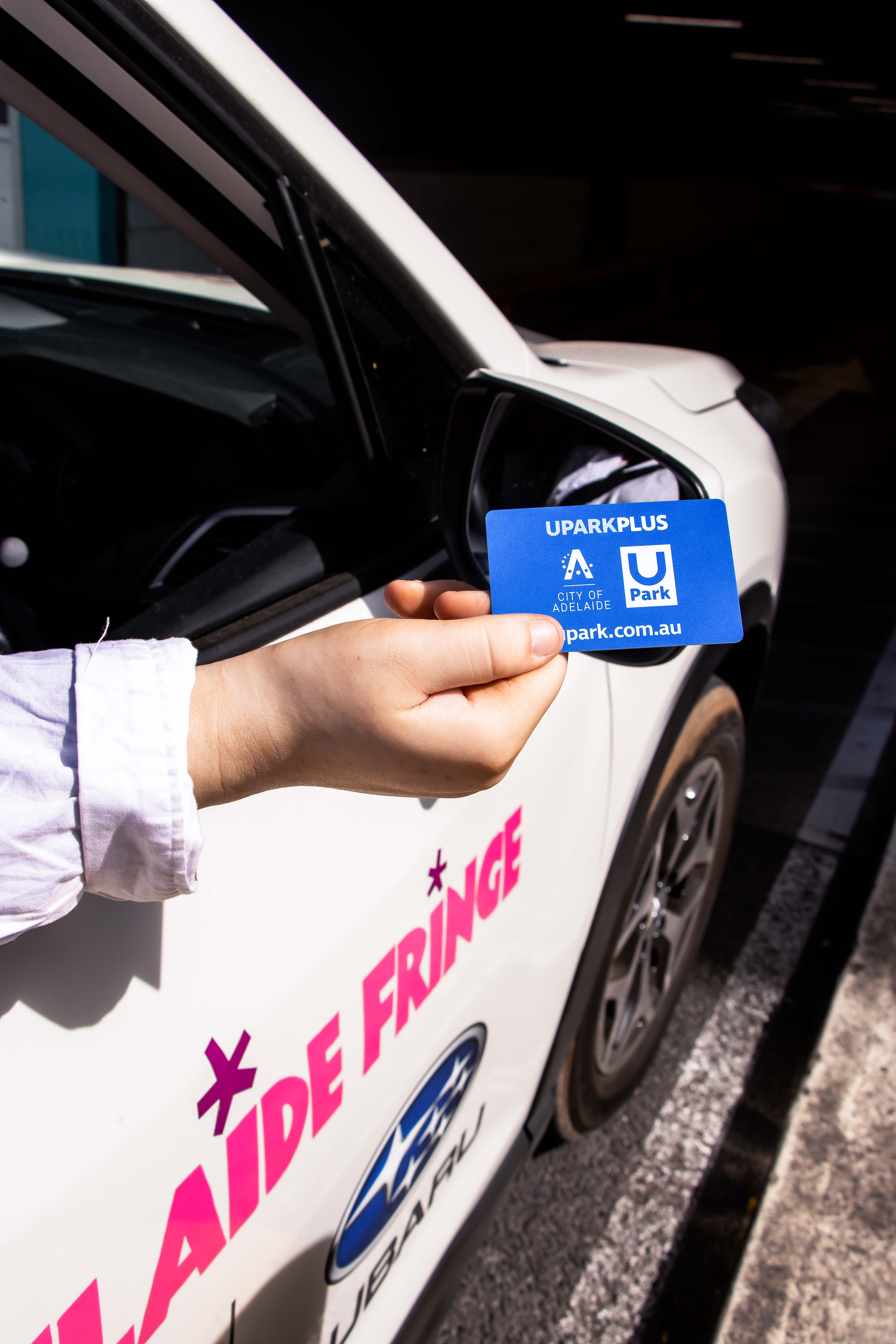 A driver of the Adelaide Fringe Subaru Outback shows their UPARKPLUS card out of the drivers side window. 