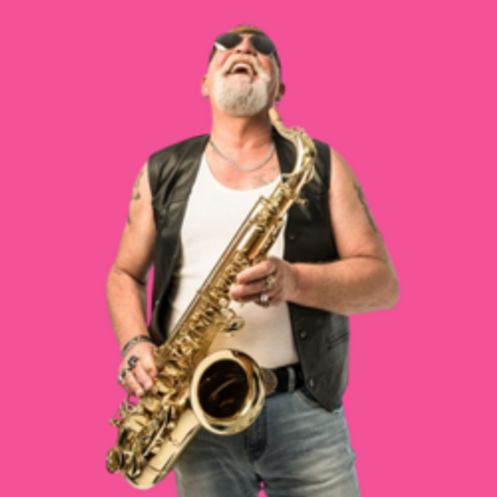 Man playing a saxophone wearing jeans, white tshirt and leather vest against a pink background