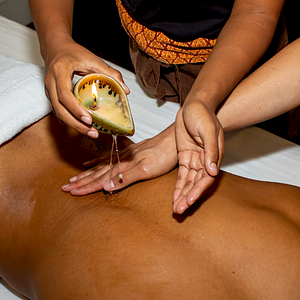 Woman pouring oil over someone's back during a massage