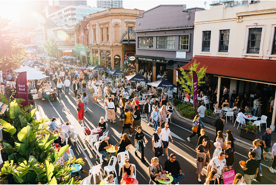 A vibrant picture of East End, Adelaide City. People are walk up and down the street while the sun is setting. 